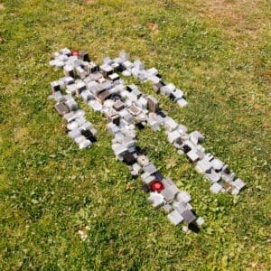 Outline of a person made from heat sink computer parts lying down in the grass